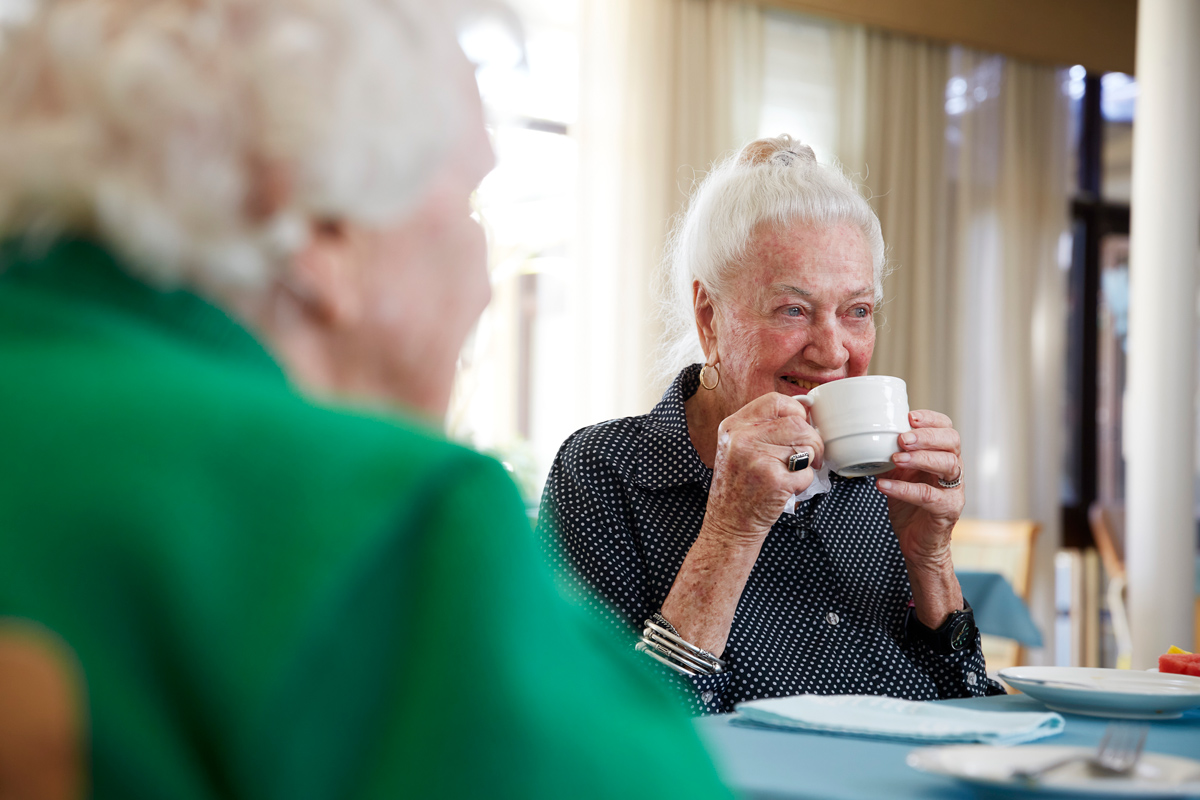 Lady enjoying cup of tea with friends