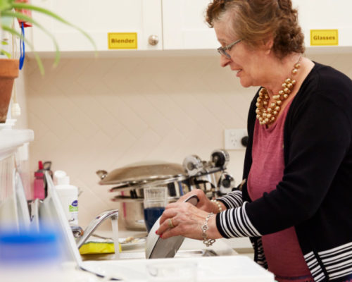 Woman doing dishes as part of her Aged Care job