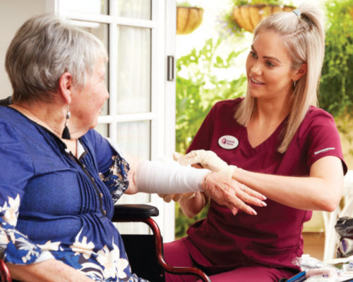 Catholic Homes Aged Care nurse bandaging her patients arm