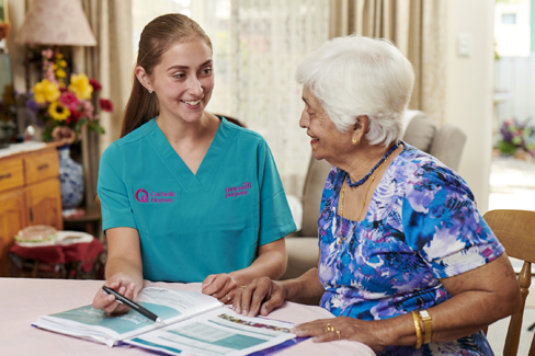 Home care worker talking through fees and charges of home care support with a client