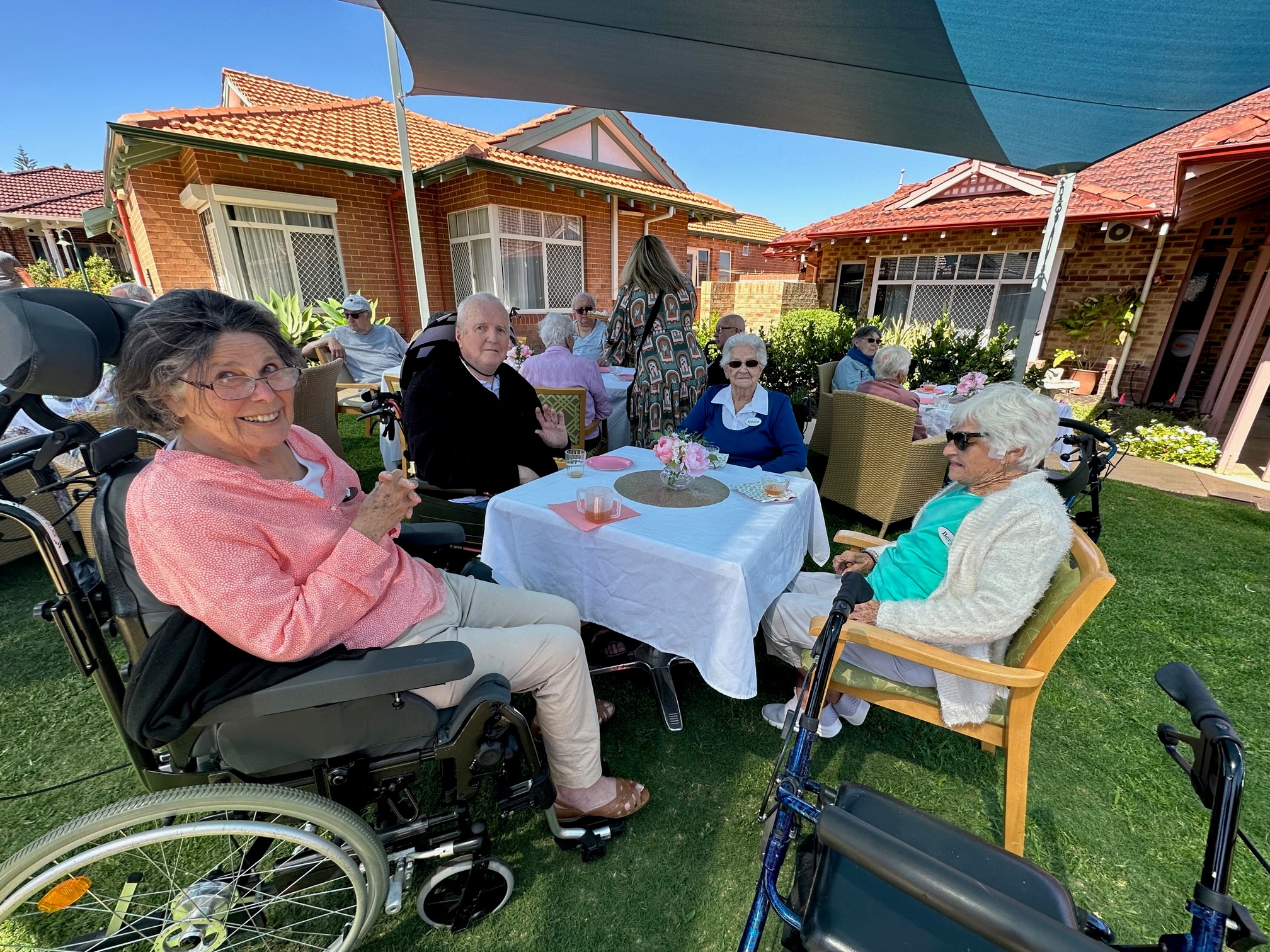 Happy residents around a table at Trinity Village celebrating its recent birthday.