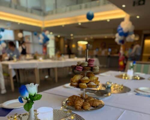 Morning tea table with pastries, macarons, flowers, and decorations at the Feast of St Vincent de Paul celebration at St Vincent’s.