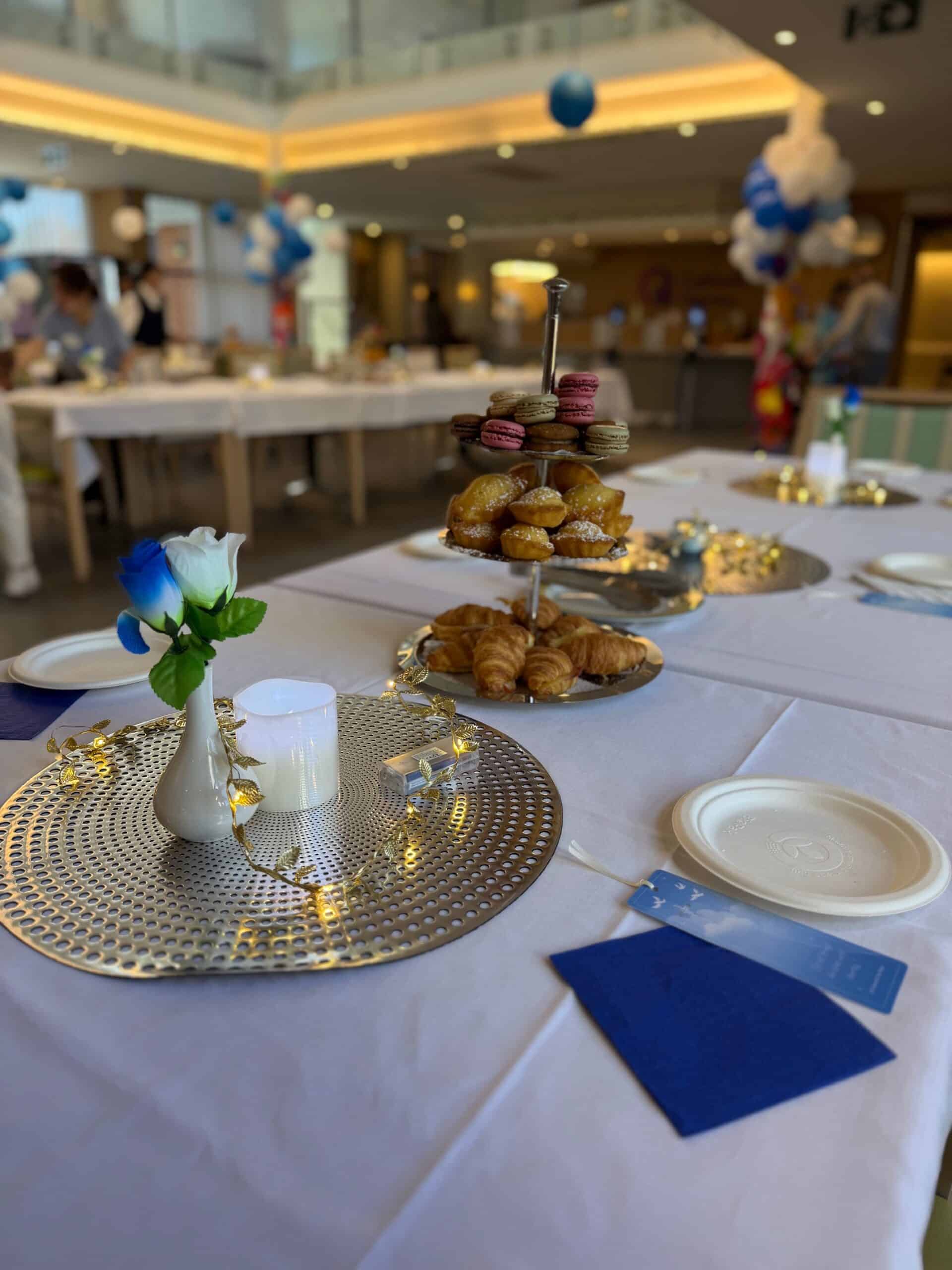 Morning tea table with pastries, macarons, flowers, and decorations at the Feast of St Vincent de Paul celebration at St Vincent’s.